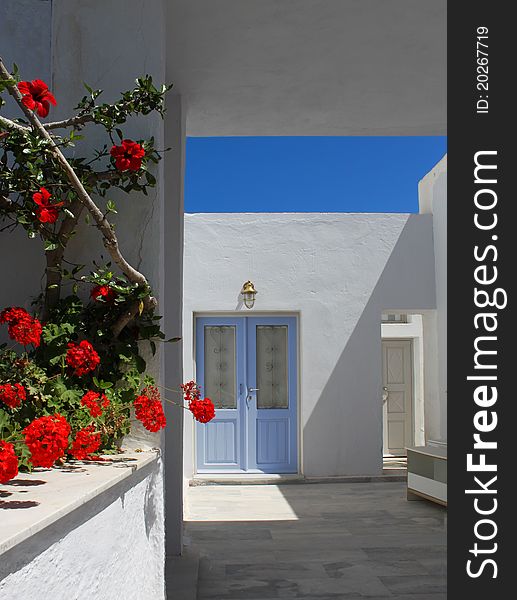 Mediterranean doorway white and blue, red flowers