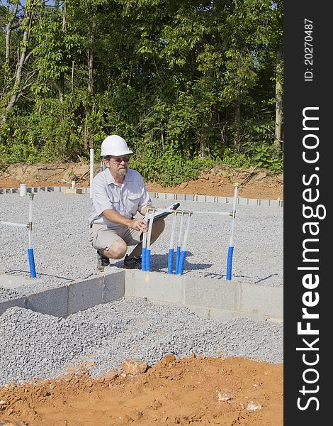 Building inspector checking new plumbing for water coming into new residential community