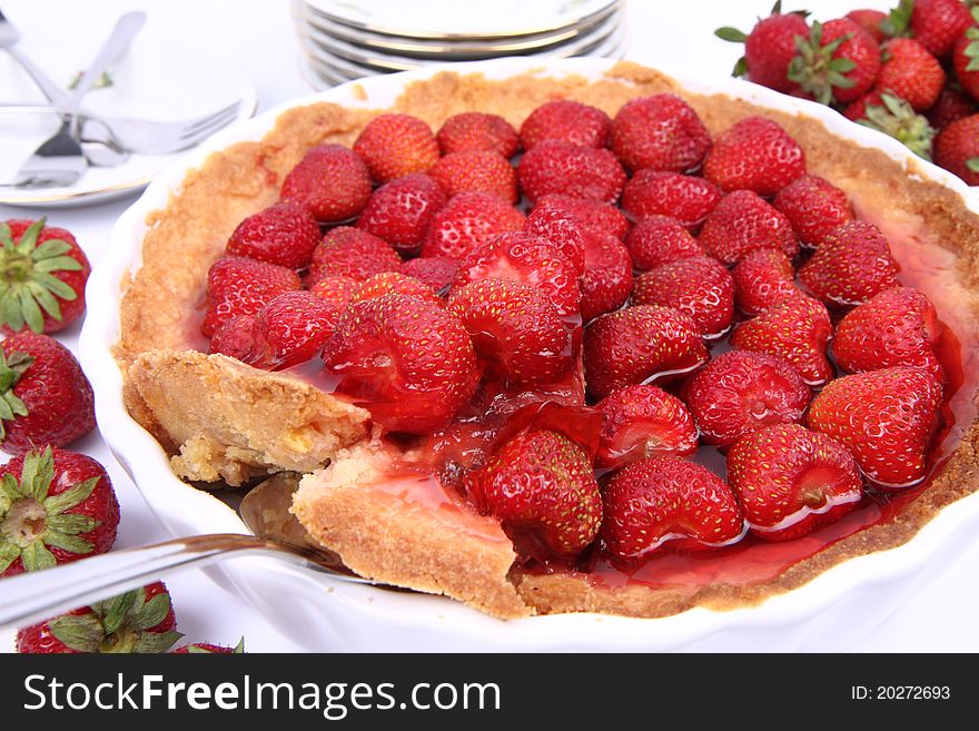 Strawberry Tart, with a portion being served, on a white background