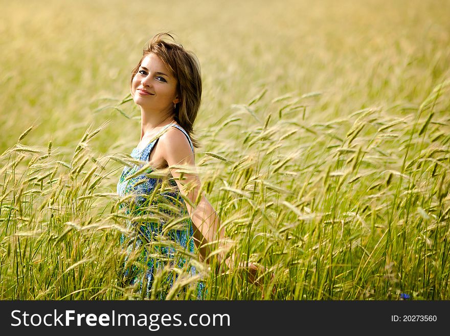 Beautiful girl smiling in a field of wheat. Beautiful girl smiling in a field of wheat