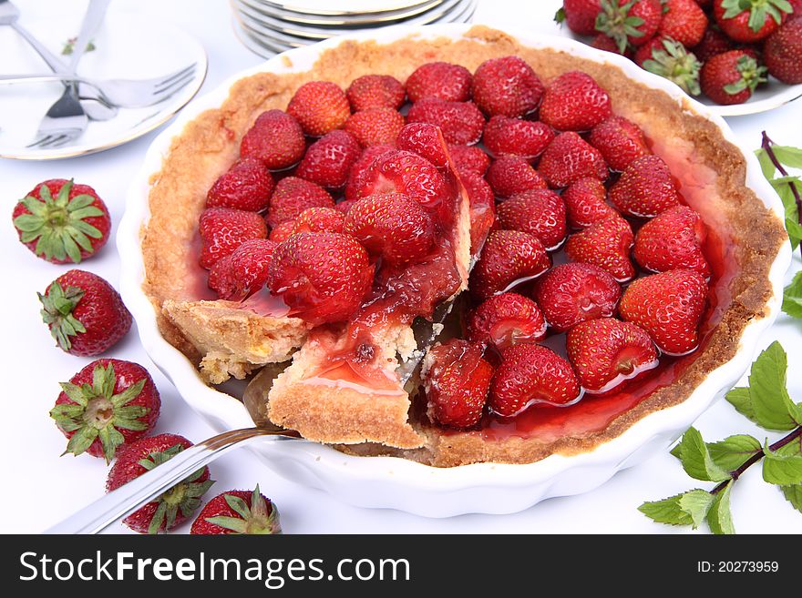 Strawberry Tart, with a portion being served, on a white background