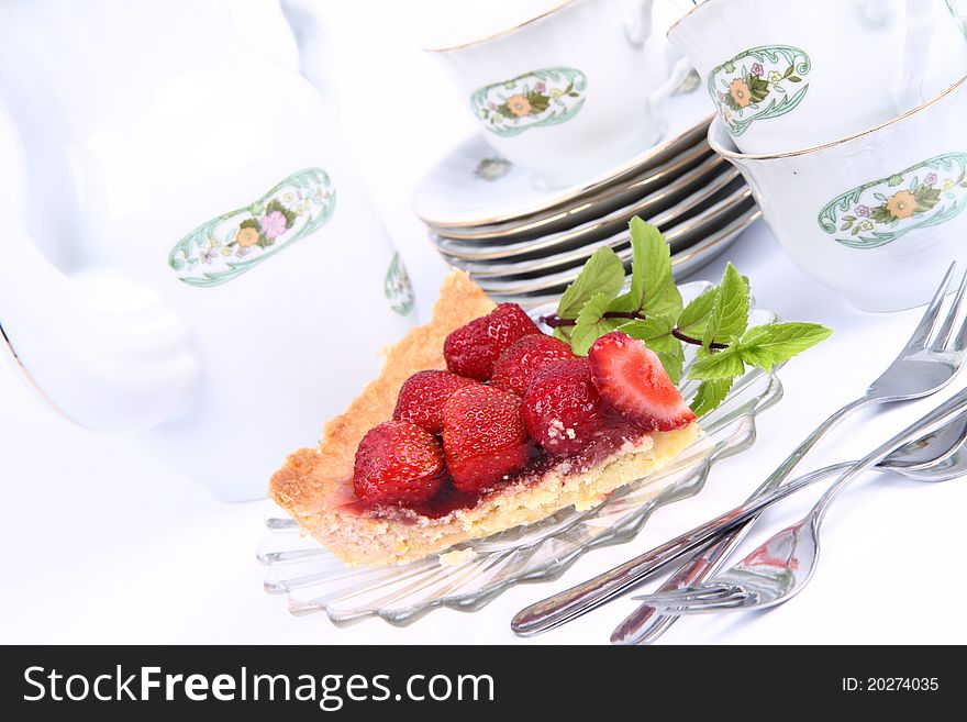 Strawberry tart, fruits, mint twig and a cup of tea