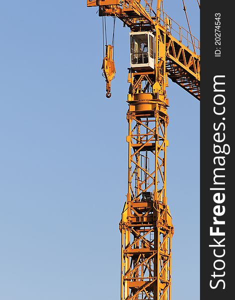 Yellow crane on building site and blue sky. Yellow crane on building site and blue sky