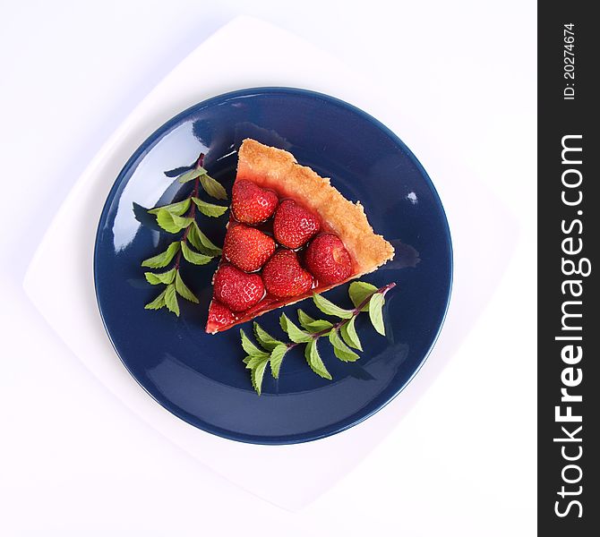 Piece of Strawberry Tart decorated with mint twigs