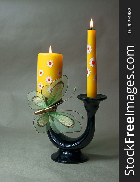 Butterfly on candlestick with burning candle