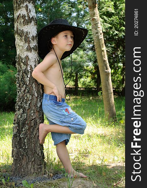 Boy in cowboy hat near the birch. Boy in cowboy hat near the birch