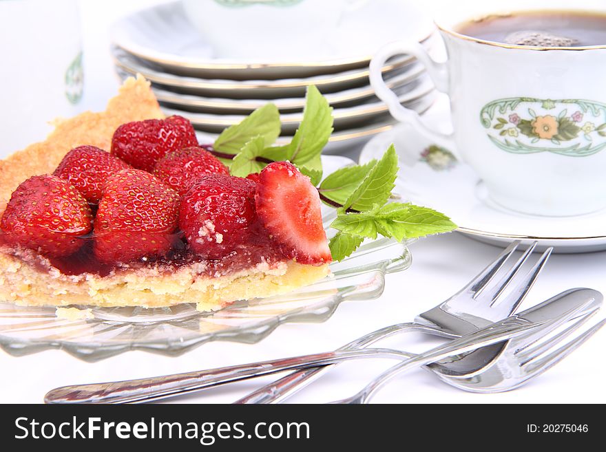 Strawberry tart, fruits, mint twig and a cup of tea