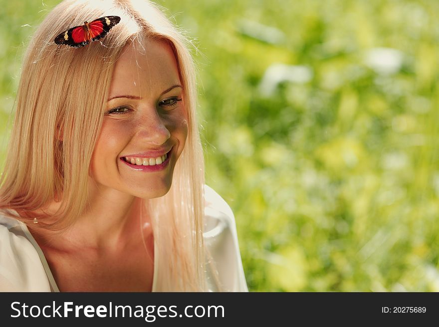 Woman playing with a butterfly on green grass