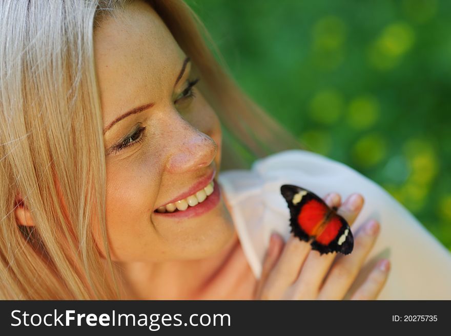 Woman playing with a butterfly on green grass