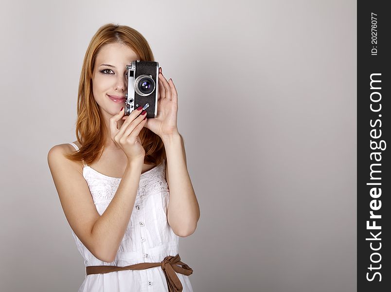 Girl in white dress with vintage camera.