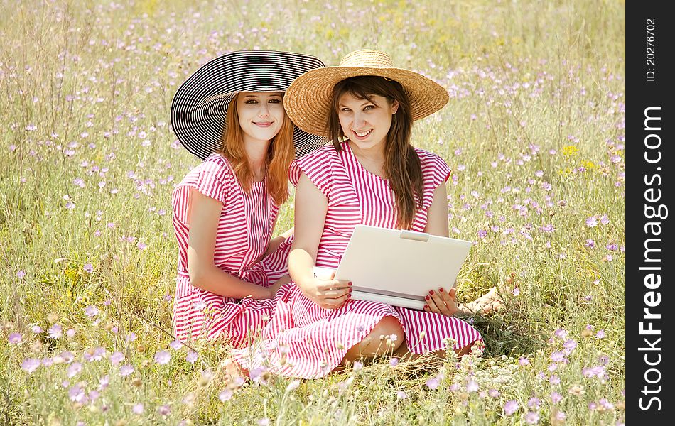 Two girls at contryside with notebook.