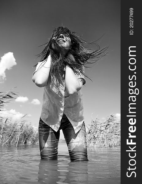 Young and beautiful savage girl in the river. Photo in noisy black and white style.