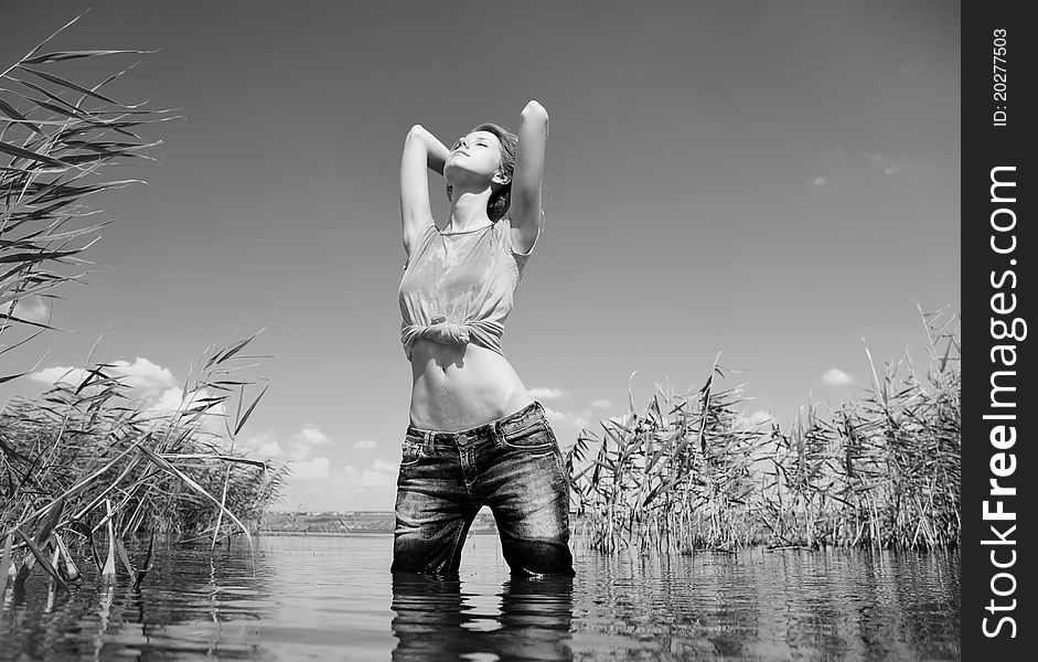 Young and beautiful savage girl in the river. Photo in noisy black and white style.