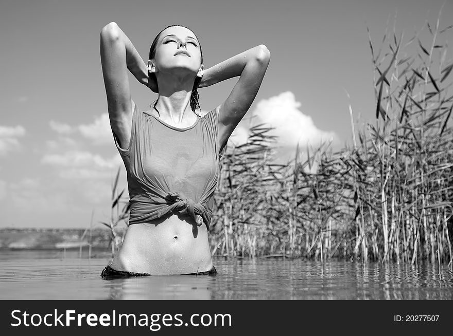 Young and beautiful savage girl in the river. Photo in noisy black and white style.