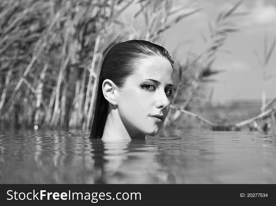 Young and beautiful savage girl in the river. Photo in noisy black and white style.