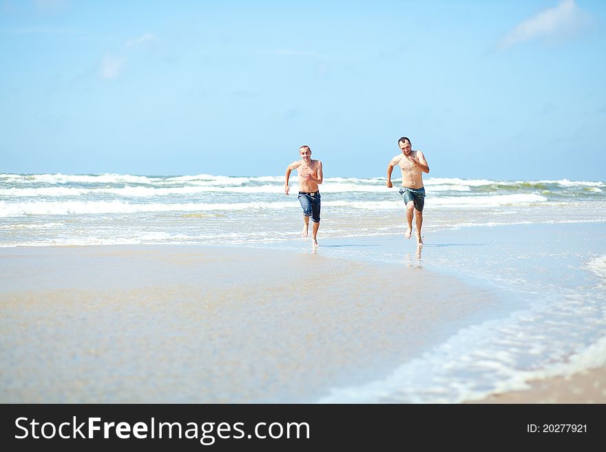 Two mans a running on the beach