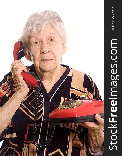 The elderly woman speaks on the phone on white. The elderly woman speaks on the phone on white