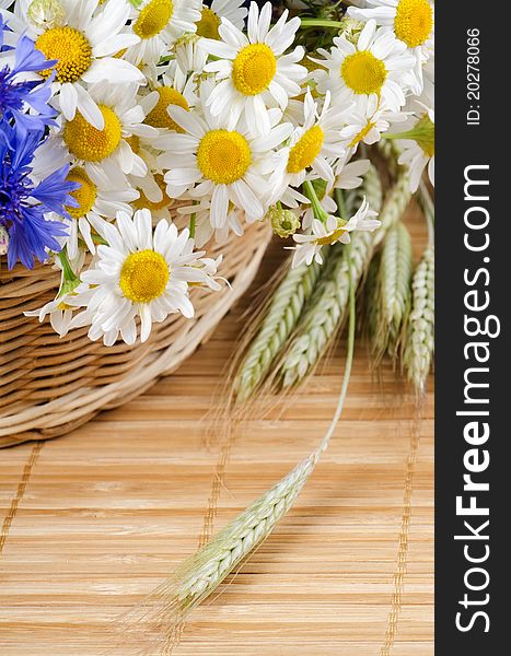 Beautiful flowers in a basket on bamboo rug