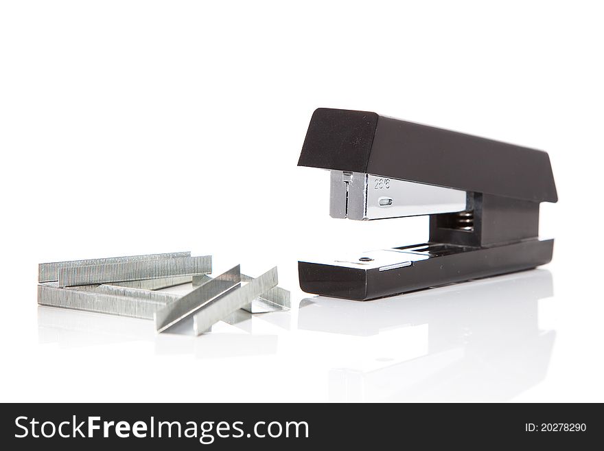 A stapler on a white background with staples next to it. A stapler on a white background with staples next to it