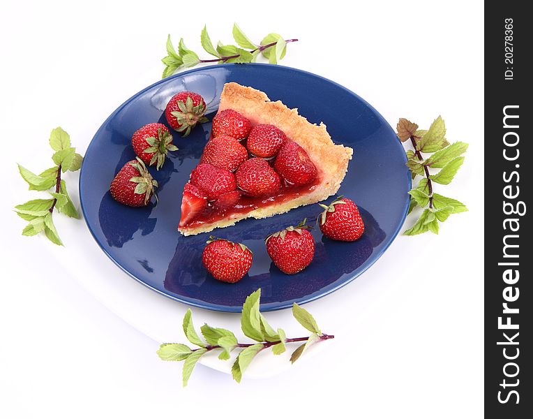 Piece of Strawberry Tart on white plate decorated with strawberries and mint twigs