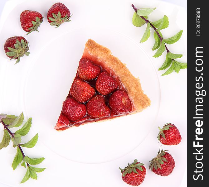 Piece of Strawberry Tart decorated with strawberries and mint