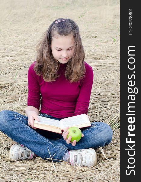 The girl with an apple on grass