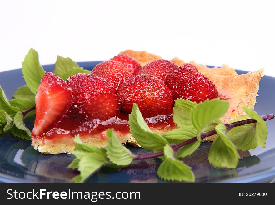 Piece of Strawberry Tart decorated with mint twigs