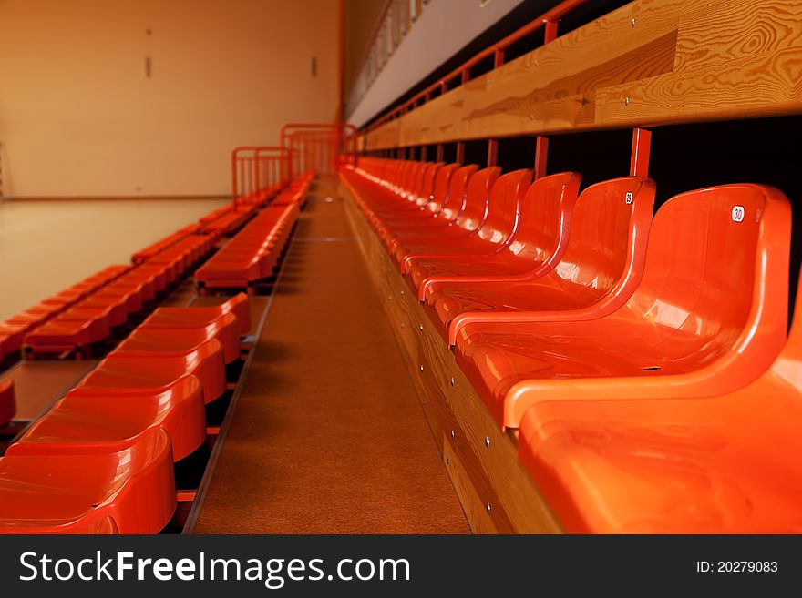 Orange, plastic seats in rows at sport indoor arena. Orange, plastic seats in rows at sport indoor arena.