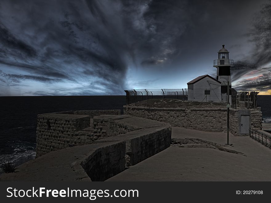 Lighhouse at the end of ancient wall at dusk. Lighhouse at the end of ancient wall at dusk