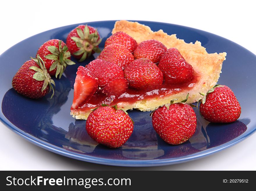 Piece of Strawberry Tart on white plate decorated with strawberries