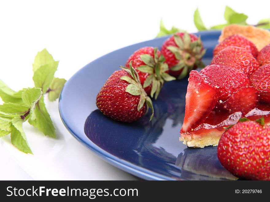 Piece of Strawberry Tart decorated with strawberries and mint