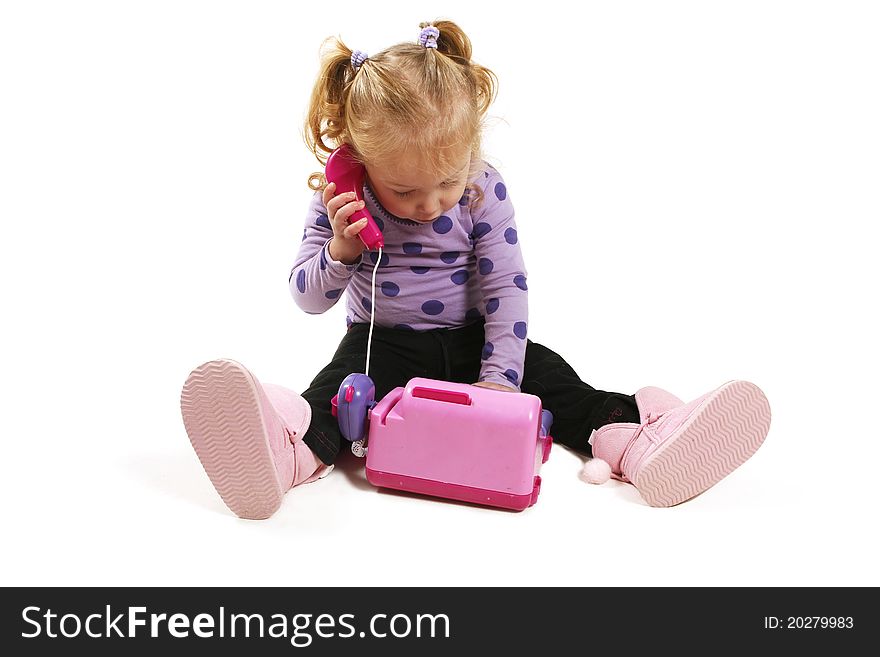 Little girl playing with pink toy phone. Little girl playing with pink toy phone