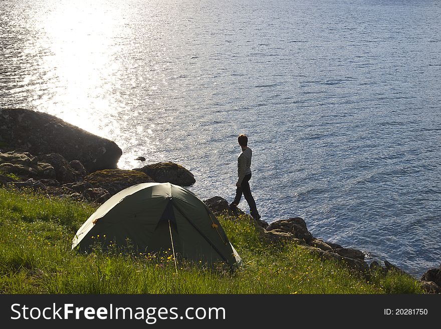 Young woman standing on sea edge and looking away