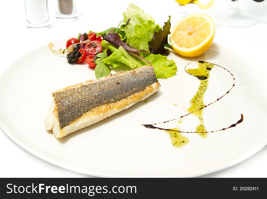 Grilled fish with salad and lemon. Grilled fish with salad and lemon