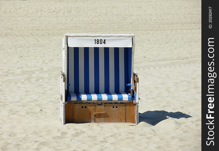 Roofed wicker chair on a white sandy beach