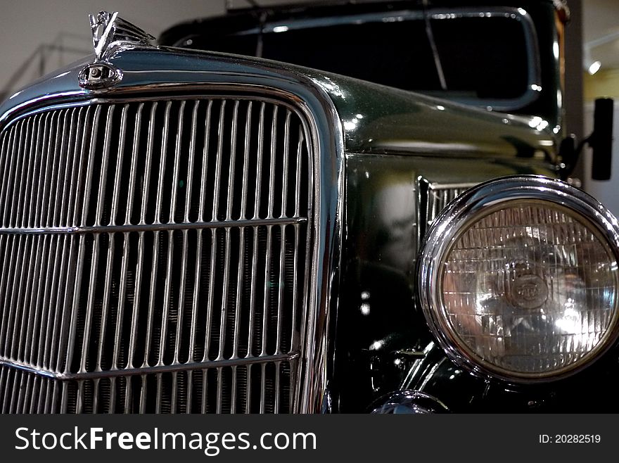 Classic car showing off its chrome grill, headlight and hood ornament. Classic car showing off its chrome grill, headlight and hood ornament