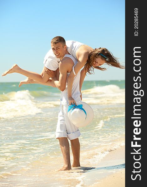 Portrait of a happy young couple having fun on the beach. Couple enjoying a summer vacation.