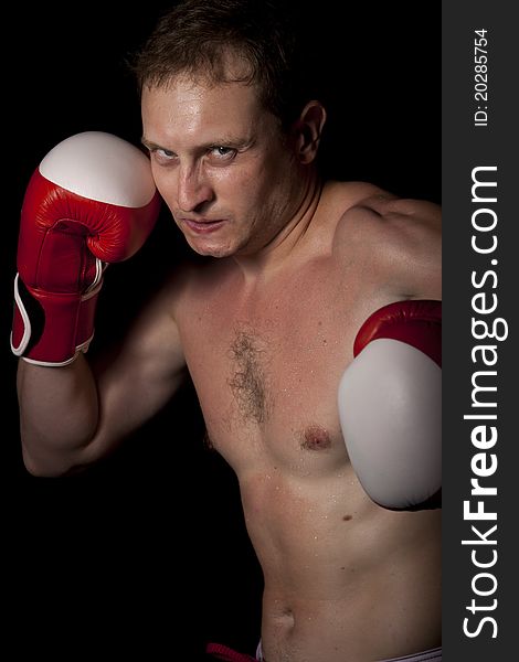 Young Boxer fighter over black background. Young Boxer fighter over black background