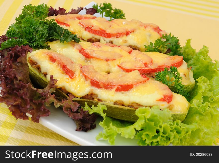 Stuffed zucchini with a mixture of vegetables with tomato and cheese with herbs