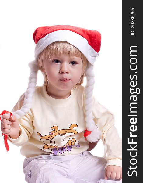 Little girl in a Christmas hat with braids on a white background