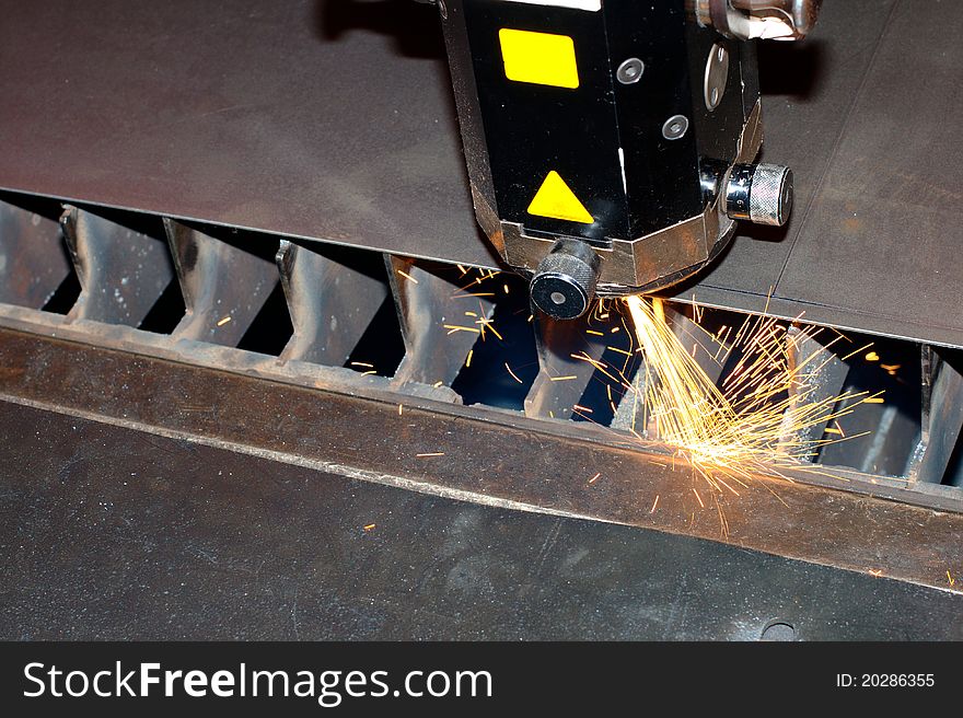 Photo of the industrial laser with sparks flying around. Photo of the industrial laser with sparks flying around