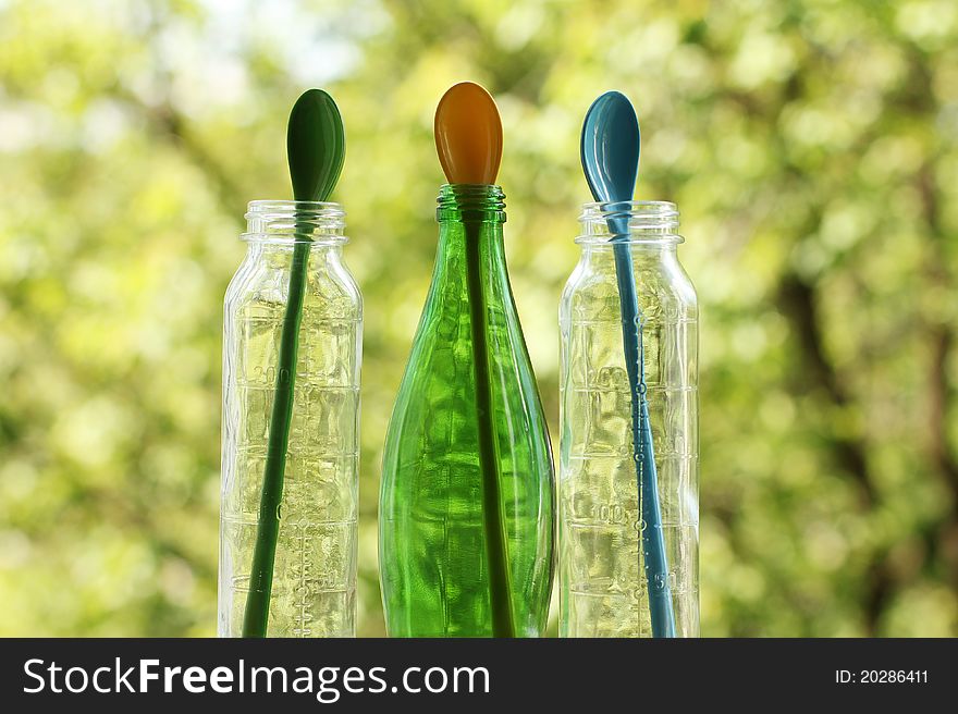 Colored glass bottles with colored spoon inside