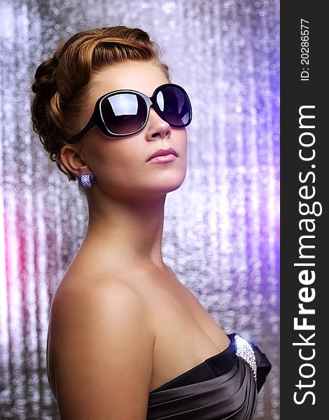 Young woman wearing sunglasses. On colored background