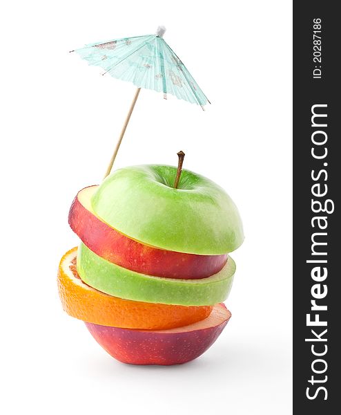 Layers of apples and oranges under umbrella isolated on white background