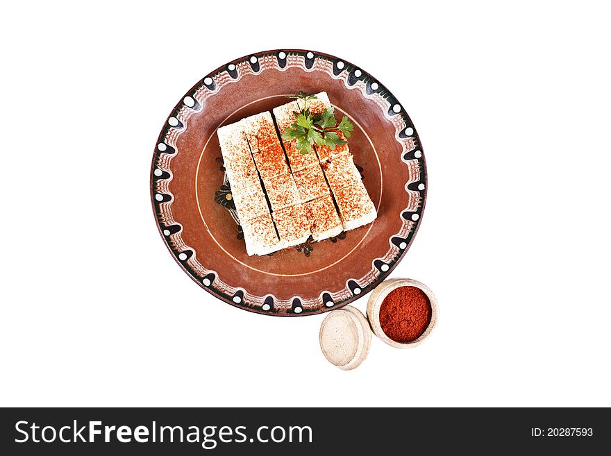 Bulgarian white cheese with paprika into a plate isolated on white. Bulgarian white cheese with paprika into a plate isolated on white