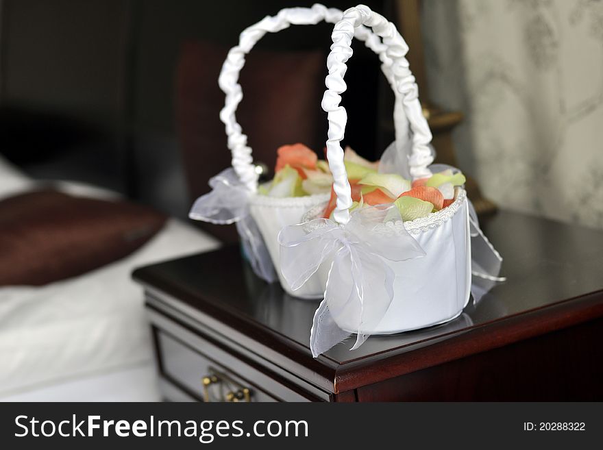 Two white punnets filled with colorful petals as a wedding decoration