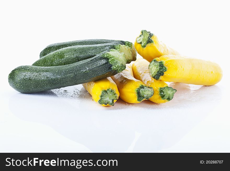 Green and yellow zucchinis on white background