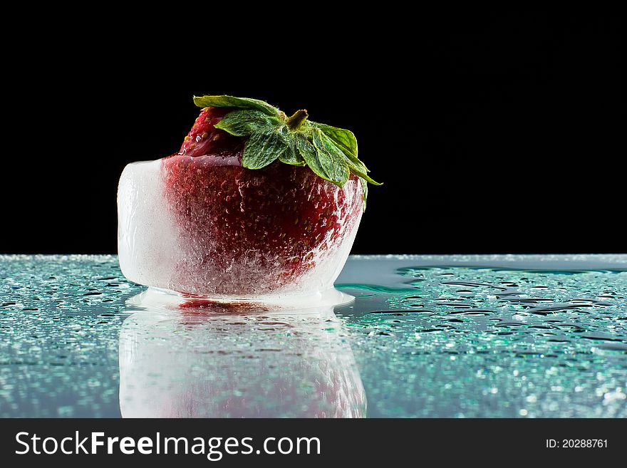 Strawberry in an ice cube on base of bathed plexiglass of drops. Strawberry in an ice cube on base of bathed plexiglass of drops