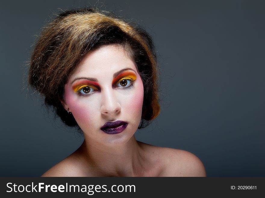 Beautiful young female against Grey with colourful make up