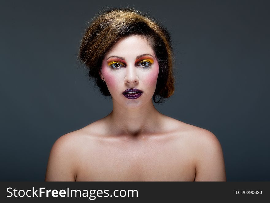 Beautiful young female against Grey with colourful make up